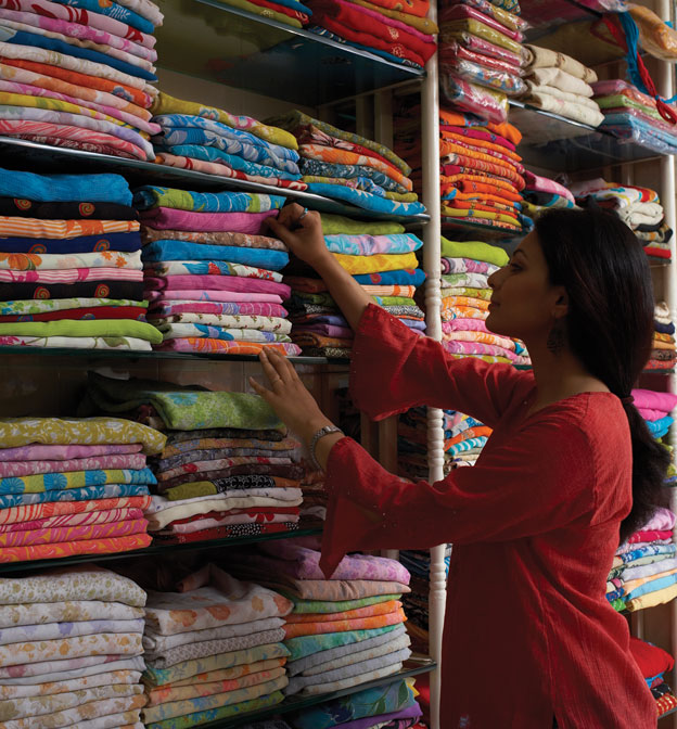 A woman shopping the traditional way, at a brick and mortar store in India.