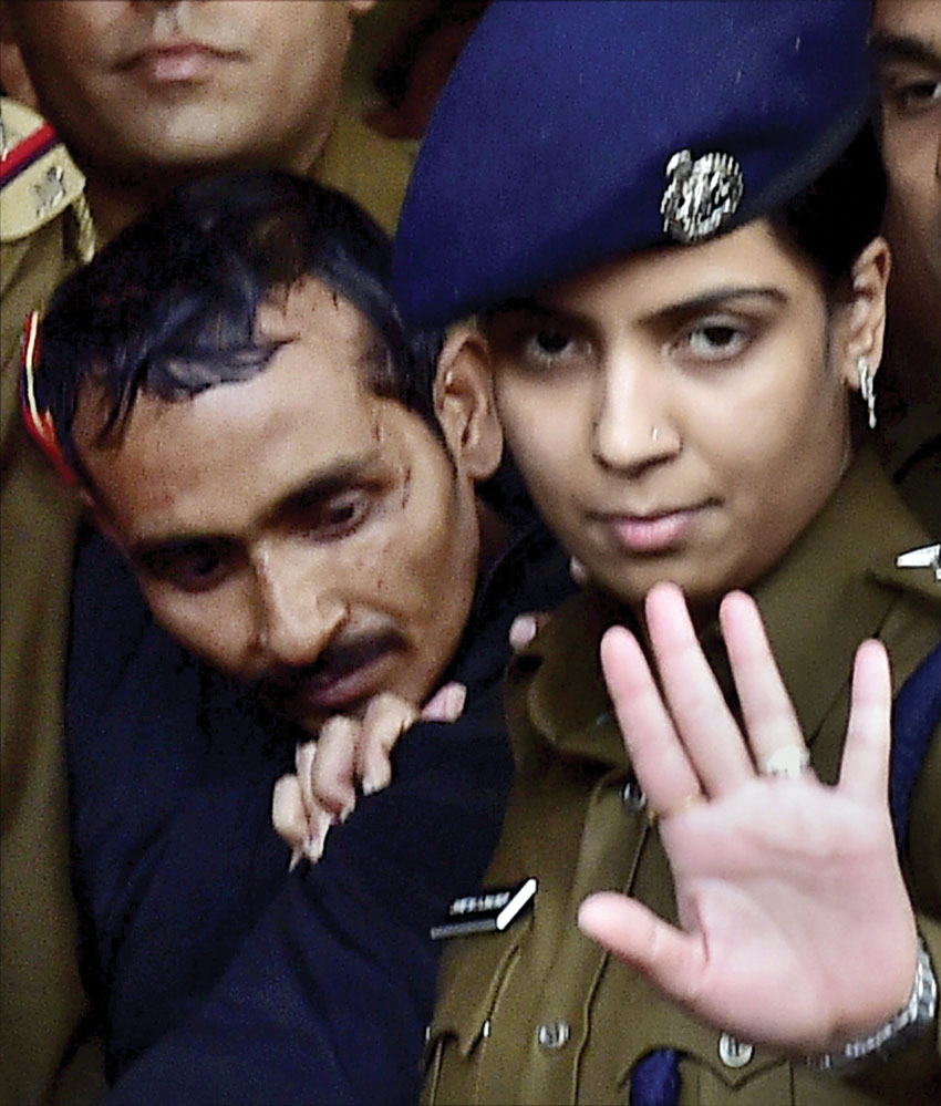 Police take away rape-accused Uber cab driver Shiv Kumar Yadav after he was produced before a Magistrate Court in New Delhi. Police arrested Yadav in Mathura on Dec. 7 for allegedly raping a 25-year-old female executive in Delhi. (Kamal Kishore | PTI)