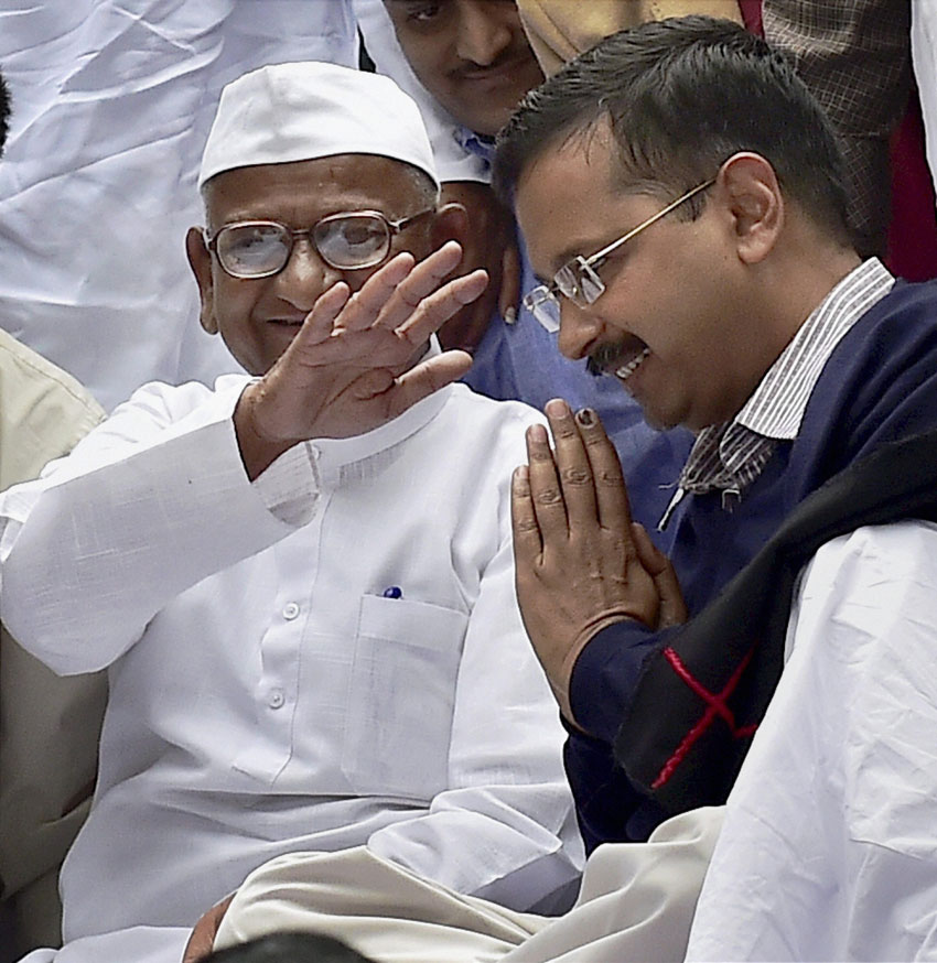 Delhi Chief Minister Arvind Kejriwal seeks blessings of social activist Anna Hazare as he shares stage with Anna on his two-day agitation against the ordinance on Land Acquisition Bill at Jantar Mantar in New Delhi, Feb. 24. (Kamal Kishore | PTI)