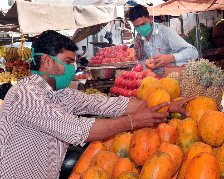 Fruit vendors use masks to protect themselves against Swine Flu virus, in Bikaner, Rajasthan, Feb. 19. (Press Trust of India)
