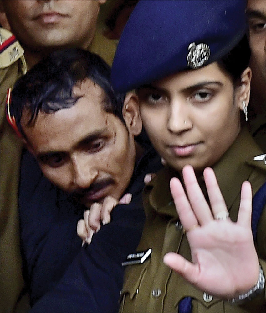 File photo of Police taking away rape accused cab driver Shiv Kumar Yadav after he was produced before a Magistrate Court in New Delhi. Police arrested Yadav in Mathura on Dec. 7 for allegedly raping a 25-year-old female executive in Delhi. The victim has recently sued Uber in a U.S. Court. (Kamal Kishore | PTI)