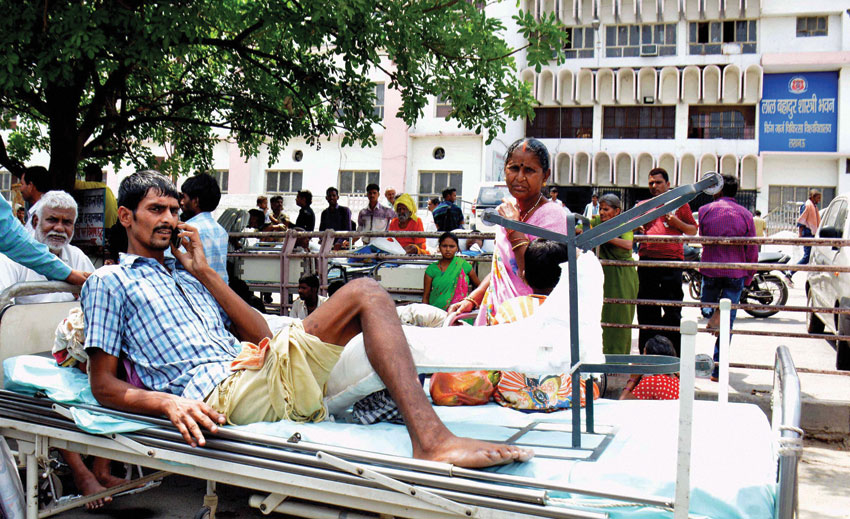 A patient lying outside a hospital, informing relatives over phone as panic grips Lucknow after tremors were felt from the 7.9 quake that hit Nepal. (Press Trust of India)