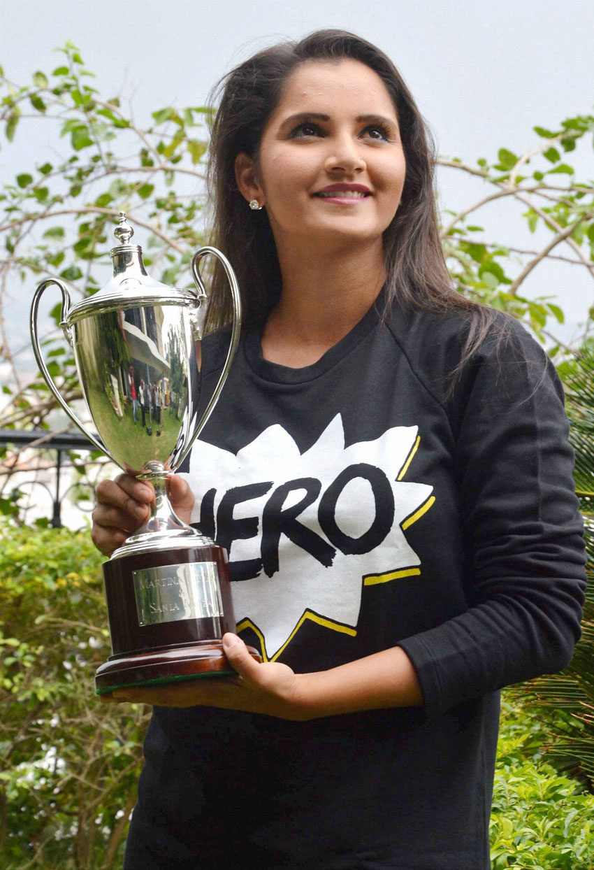 Sania Mirza poses for photographs with the Wimbledon Doubles trophy that she won recently, at a news conference at her residence, in Hyderabad, July 14. (Press Trust of India) 
