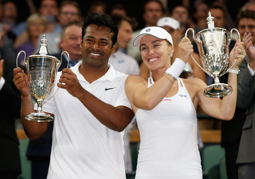 Leander Paes of India (l) and Martina Hingis of Switzerland hold the trophies after winning the mixed doubles final against Alexander Peya of Austria and Timea Babos of Hungary at the All England Lawn Tennis Championships in Wimbledon, London, July 12. (Alastair Grant | AP) 