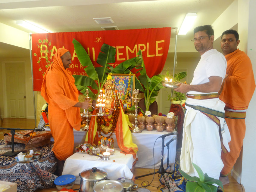Swami Narayananda performing “aarti” with priests. 