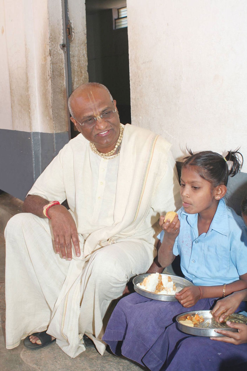 Akshaya Patra founder and chairman Madhu Pandit Dasa chats with a child. (Akshaya Patra) 