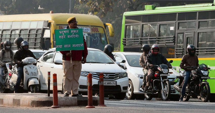 A Civil Defense volunteer holding a placard at ITO as Odd-Even scheme restricting movement of private cars, is operational in New Delhi, Jan. 2. (Shahbaz Khan | PTI) 