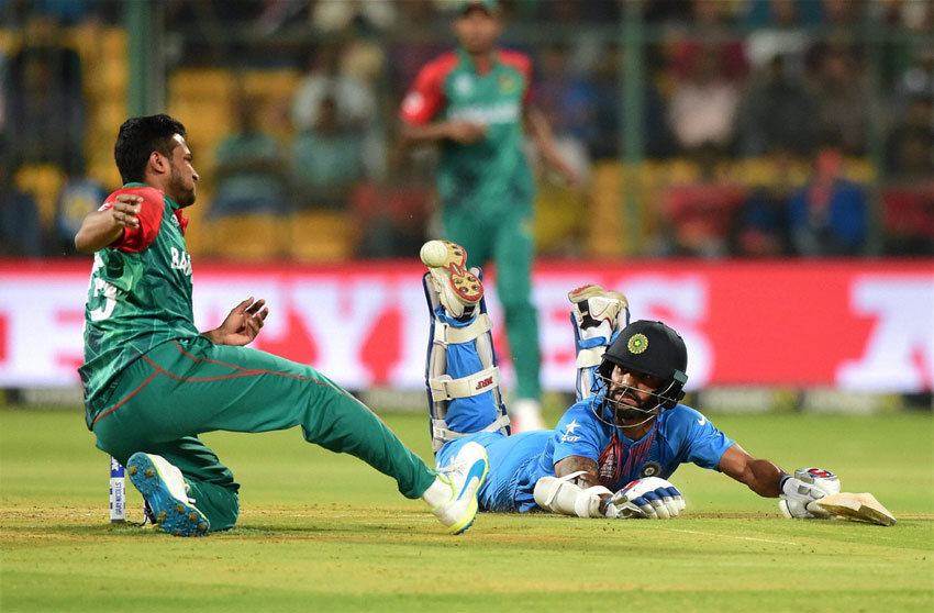 India's Shikhar Dhawan dives to reach the crease during the World T20 match against Bangladesh at Chinnaswamy Stadium in Bengaluru, Mar. 23. (Shailendra Bhojak | PTI) 