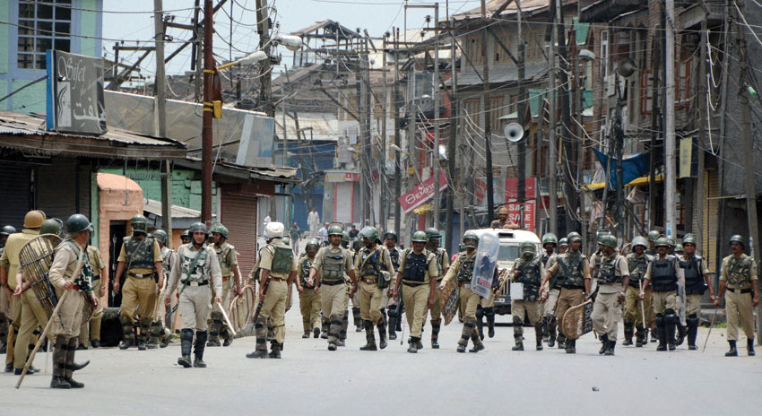 CRPF Personnel move towards their camp as curfew was lifted after 17 days, at Safa Kadal, a town in the Srinagar district, July 26. (Press Trust of India) 