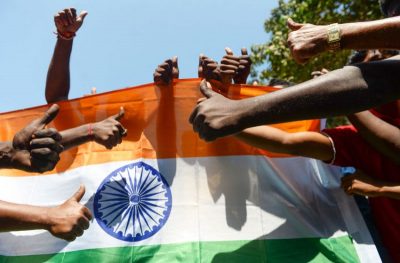 Indian residents raise their thumbs in front of the national flag as they participate in a demonstration to support Indian armed forces in Chennai, Feb. 26, following an Indian Air Force (IAF) strike launched on a Jaish-e-Mohammad (JeM) camp at Balakot. (Arun Sankar/AFP/Getty Images)