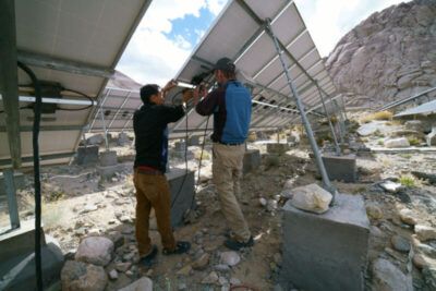 (Above): Solar engineers are seen repairing some solar panels at the Tangste power plant in Ladakh, India, Sept. 2016. (Rahul Ramachandram/Shutterstock)